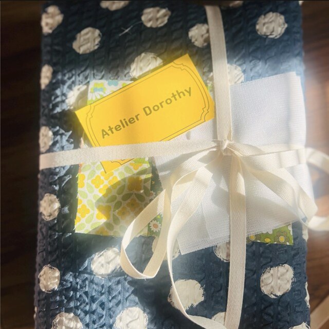 An Atelier Dorothy fabric order wrapped with ribbon and a yellow shop tag