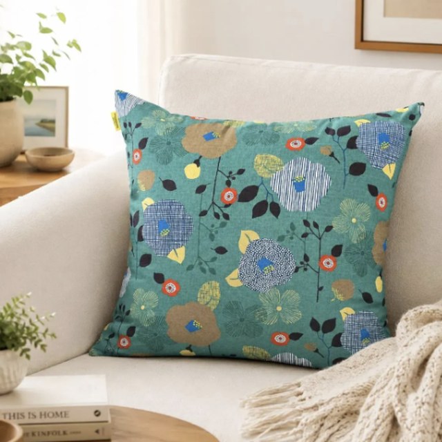 Botanical Bloom Sage Green Kyoto cotton pillow cover on a cream armchair
